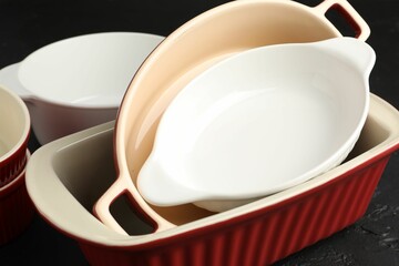 Many different casseroles on black table, closeup
