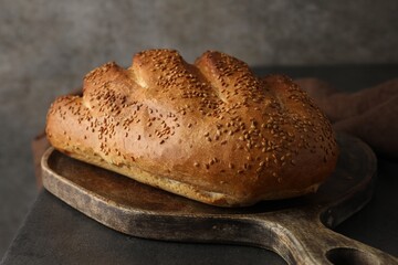 Freshly baked bread with seeds on grey table, closeup