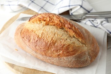 Loaf of delicious bread on white wooden table, closeup