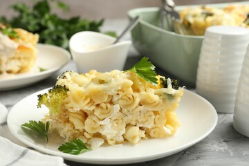Tasty pasta casserole with cheese and broccoli served on grey table, closeup