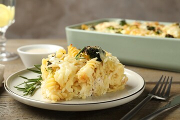 Tasty pasta casserole with cheese and broccoli served on wooden table, closeup
