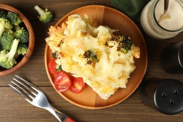 Tasty pasta casserole with cheese and broccoli served on wooden table, flat lay