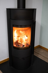 A black stove with a fire burning inside