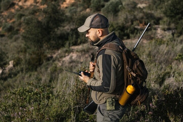 Hunter using walkie talkie during hunting trip in the forest