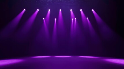 Purple stage lighting illuminates a dark room, creating dramatic beams of light.