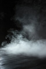 Fototapeta premium Dark atmospheric setting with swirling smoke and fog perfect for horror-themed presentations or product displays in a theatrical environment