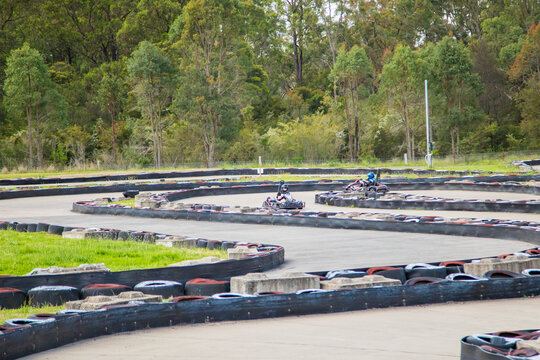 People driving go karts around outdoor track