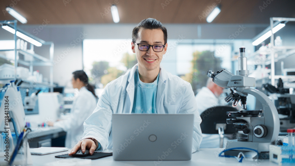 Aufkleber Portrait of a Handsome Young Multiethnic Lab Engineer in White Coat Looking at Camera and Smiling. Genetic Research Scientist Working on a Laptop Computer in an Applied Science Laboratory
