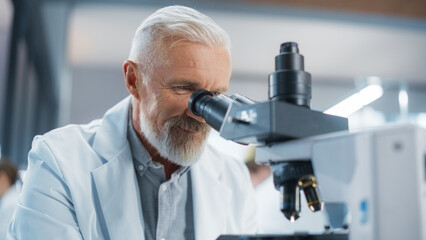 Senior Medical Research Scientist Looking at Biological Samples Under a Microscope in an Applied...