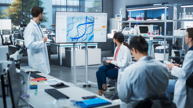 Head of Laboratory Making a Bioengineering Lecture for a Group of Young Science College Students. Promising Female Student Asking Teacher a Question About a DNA Gene Editing Process