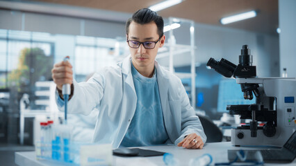 Medical Research Laboratory: Portrait of a Handsome Scientist Using Micropipette to Analyze Samples Under Microscope. Advanced Scientific Lab for Medicine, Biotechnology, Microbiology Development