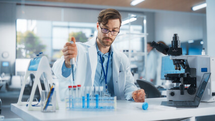 Fototapeta premium Portrait of a Handsome Scientist Using Micropipette to Analyze Genetic Samples Under Microscope. Advanced Scientific Medical Research Laboratory for Microbiology Products Development