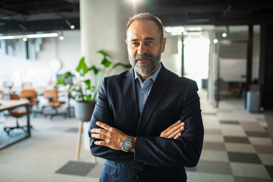 Portrait of a confident businessman in suit standing in modern office