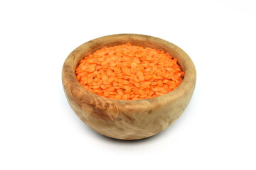 Red lentils in a wooden bowl isolated on white background. Red lentils pile isolated. Dry orange lentil grains, round heap of dal, spilled raw daal, dhal, masoor on white 