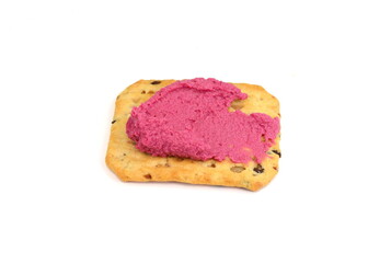Beetroot hummus spread on a cracker isolated on white background 