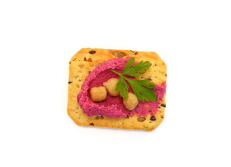 Beetroot hummus spread on a cracker isolated on white background 