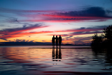 Fototapeta premium Silhouetted figures admire a sunset, reflecting serenity and contemplation