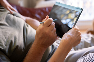 Close-up of the hands of a retired couple with the screen of a tablet
