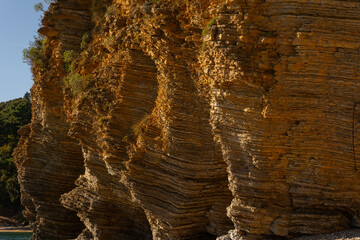 layered rocks of the sea cliff in Budva.