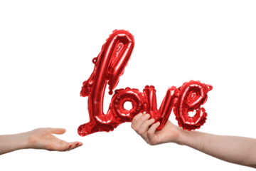 Two hands reach out to each other, one holding a shiny red balloon shaped like the word love, symbolizing connection and romance