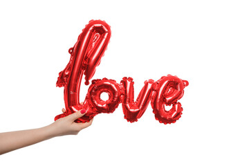 Fototapeta premium Hand holding a red balloon forming the word love against a plain background for celebration or decoration