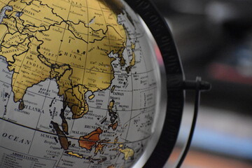 A close-up of a golden globe, showcasing Asia