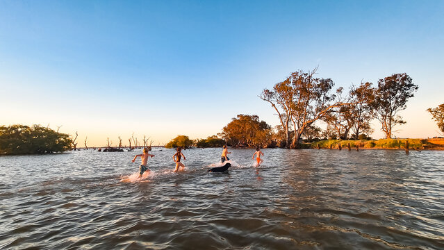 Kids swimming at Kow Swamp in rural Victoria at sunset