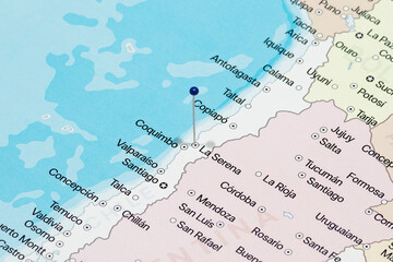 Macro photo of a blue pin needle into Serena city of Chile political map