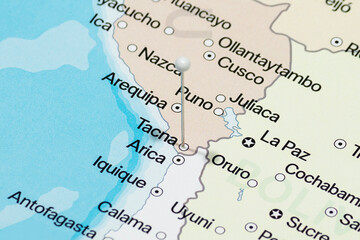 Fototapeta premium Macro photo of a white pin needle into Tacna city of Peru political map 