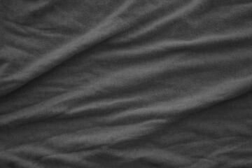 Texture of Dark grey crumpled textile cloth part with small folds