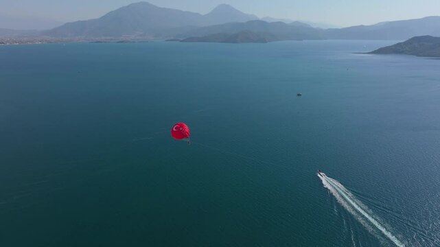 Aerial view of parasailing over the beautiful Mediterranean Sea with serene islands and tranquil mountains, Fethiye, Turkey.