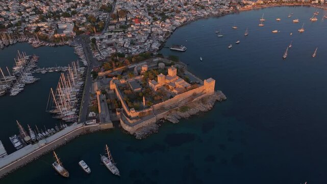 Aerial view of bodrum castle at sunset by the aegean sea with boats in the harbor, bodrum, turkey.