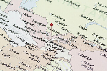 Macro photo of a red pin needle into Istaravshan city of Tajikistan political map 