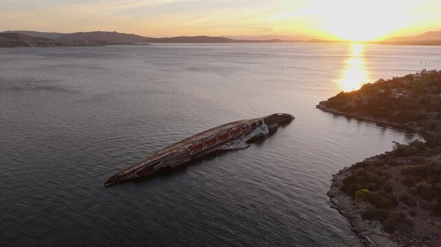 Eleusis, Greece - 01 December 2024: Aerial view of the shipwreck MS Mediterranean Sky in the serene gulf of Elefsina at sunset, Eleusis, Greece.