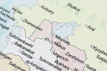 Macro photo of a white pin needle into Nukus city of Uzbekistan political map 