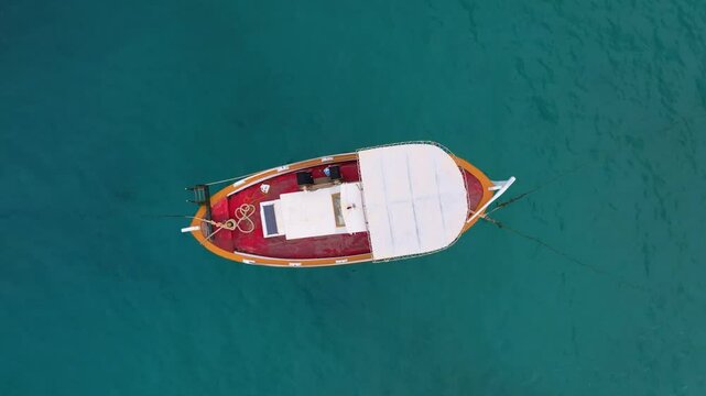 Aerial view of tranquil turquoise waters with boats floating in the Mediterranean Sea, Limeni, Greece.