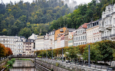Historische Kurstadt Karlovy Vary mit eleganten Fassaden und grüner Hügelkulisse entlang der...