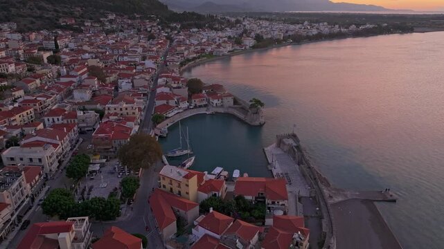 Aerial view of nafpaktos venetian port at sunrise with beautiful rooftops and serene sea, Nafpaktos, Greece.