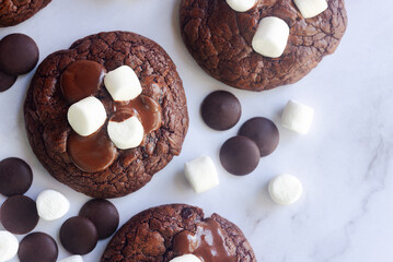 Homemade chocolate brownie cookies decorating with marshmallow on top on white marble table.