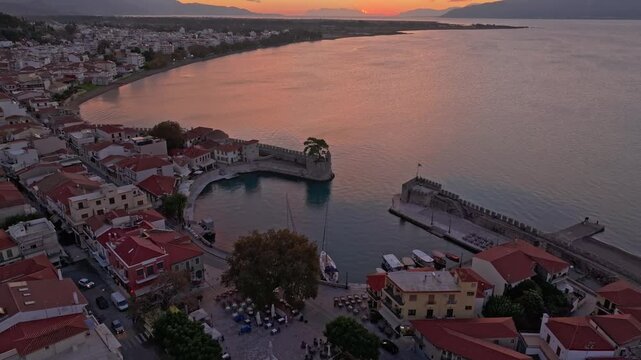 Aerial view of nafpaktos venetian port at sunrise with beautiful coastal town and scenic mountains, Nafpaktos, Greece.