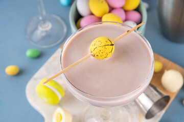 Easter chocolate sweet martini alcohol cocktail, cream and vodka alcohol beverage with a lot of chocolate mini eggs on kitchen table, copy space