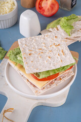 Tasty matzah sandwich with tuna, cheese, lettuce and vegetables. Viral club sandwich for Passover. Food ideas and recipe for Jewish Pesach holiday