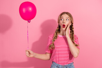 Charming young woman with braided hair holding a pink balloon against a vibrant background