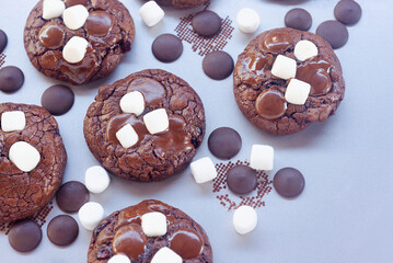 Homemade chocolate brownie cookies decorating with marshmallow on top on baking tray.