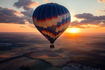 Obraz premium Hot air balloon floats above fields during sunset over a picturesque landscape
