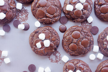 Homemade chocolate brownie cookies decorating with marshmallow on top on baking tray.