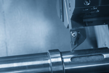 The CNC lathe machine forming  cutting the metal shaft parts in the light blue scene with lighting effect.