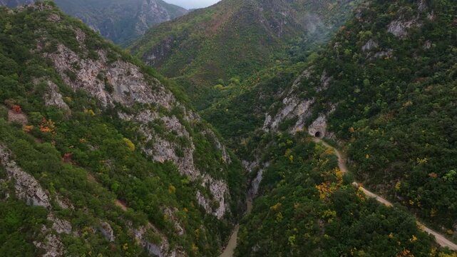 Aerial view of the beautiful Acheron Springs with a serene river flowing through a rugged canyon surrounded by lush greenery and majestic mountains, Epirus, Greece.