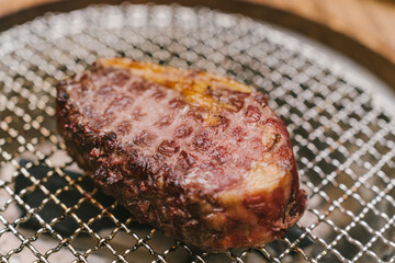 A piece of meat is on a metal pan