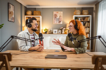 two radio hosts smile and enjoy while record podcast in studio